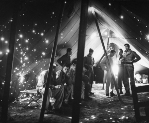 American soldiers inside hospital tent riddled w. holes caused by German schrapnel from long range gun attacks which killed 5 & wounded 8 patients in the tent. Photograph by George Silk. Life Magazine