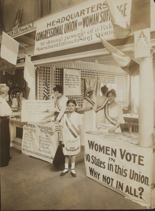 girl in front of suffrage signs